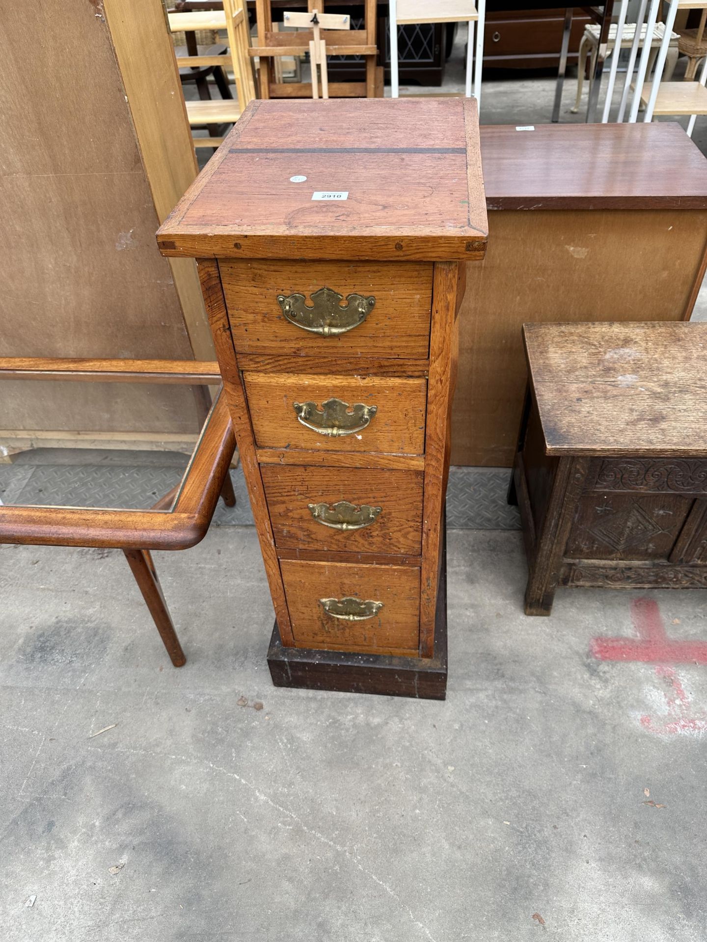 A NARROW OAK EDWARDIAN CHEST OF FOUR GRADUATED DRAWERS WITH BRASS HANDLES, 13" WIDE CONTAINING A