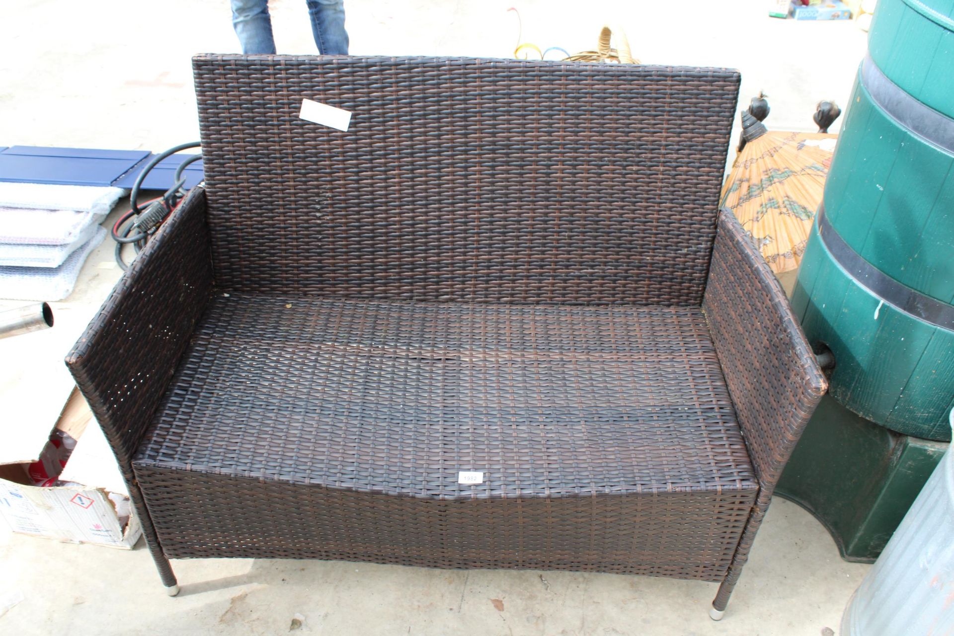 A TWO SEATER RATTAN GARDEN SETTEE