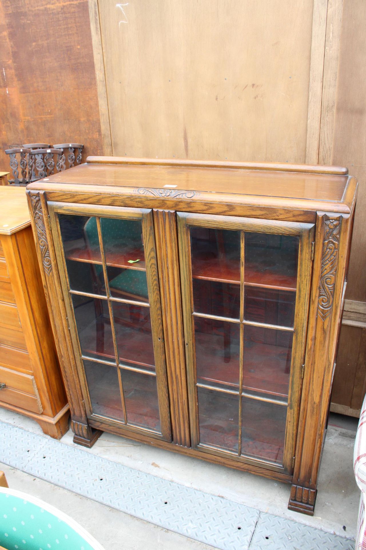 AN EARLY 20TH CENTURY OAK TWO DOOR GLAZED BOOKCASE, 42" WIDE