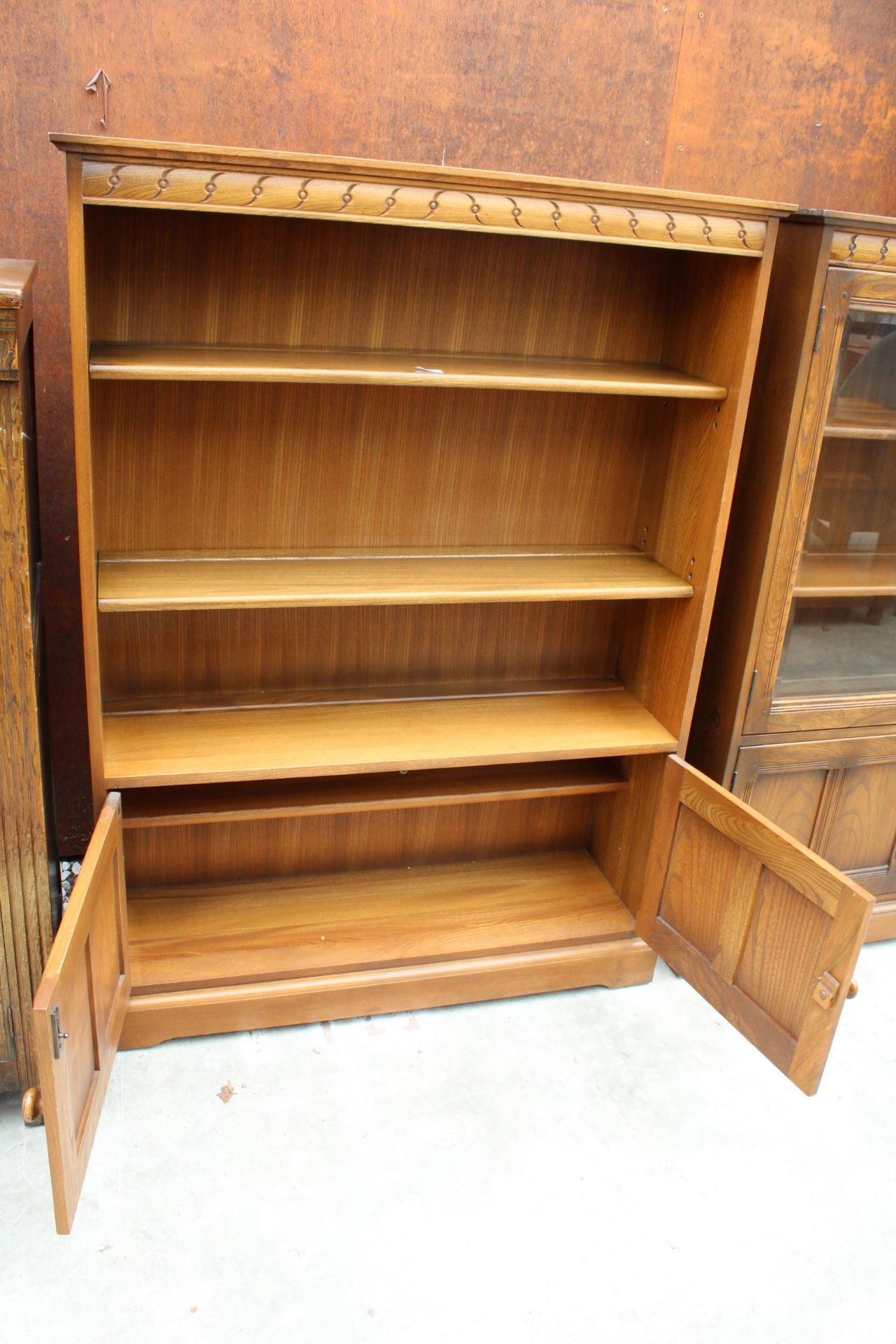 AN ERCOL BLONDE THREE TIER OPEN BOOKCASE WITH CUPBOARD TO BASE, 39.5" WIDE - Image 3 of 4