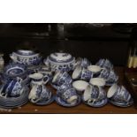 A BLUE AND WHITE WILLOW PATTERN PART DINNER SERVICE TO INCLUDE SERVING TUREENS, BOWLS, SUGAR BOWL,