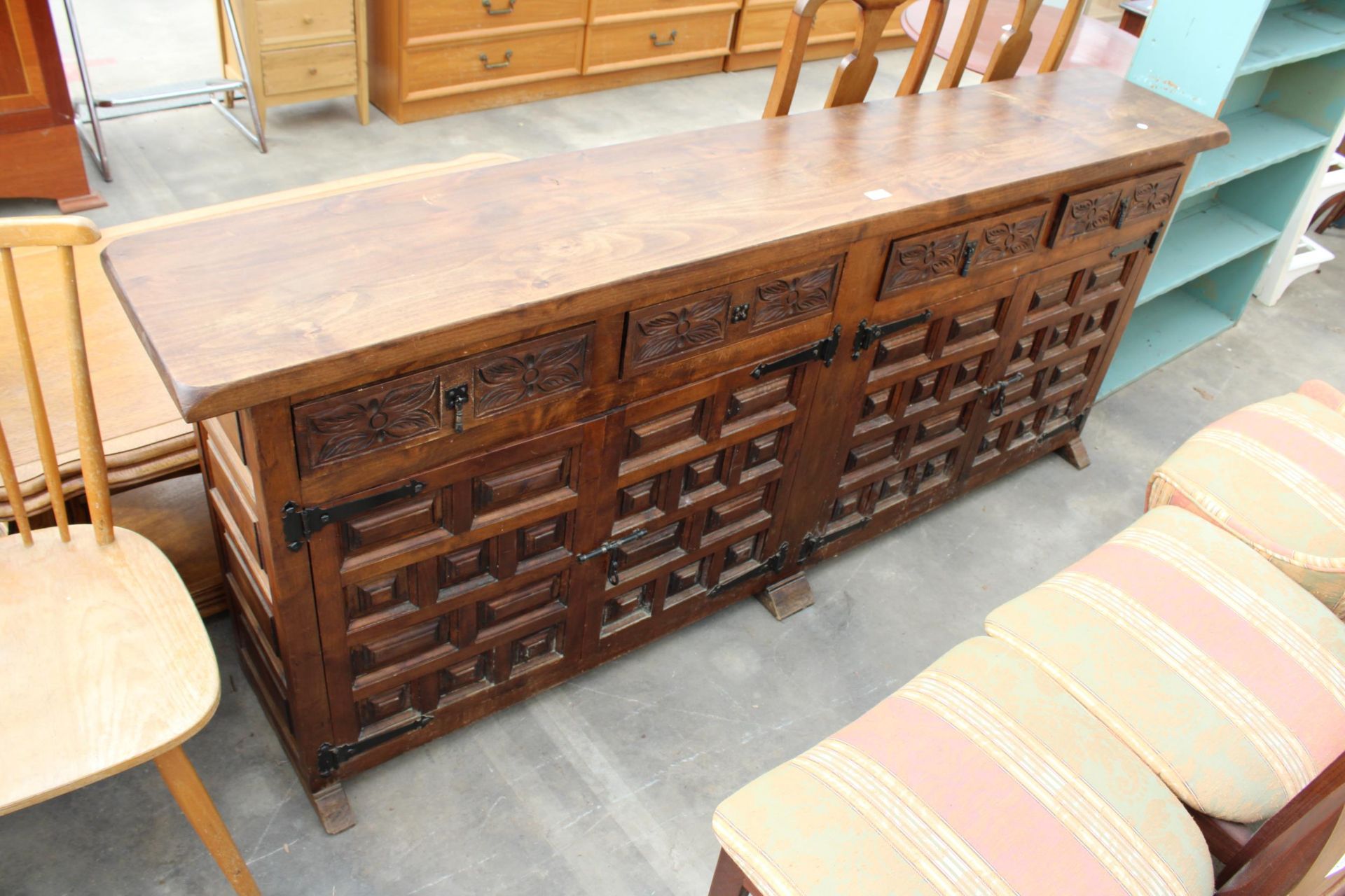 A MODERN SPANISH STYLE HARDWOOD SIDEBOARD WITH RAISED PANEL DOORS AND CARVED DRAWERS, 77" WIDE