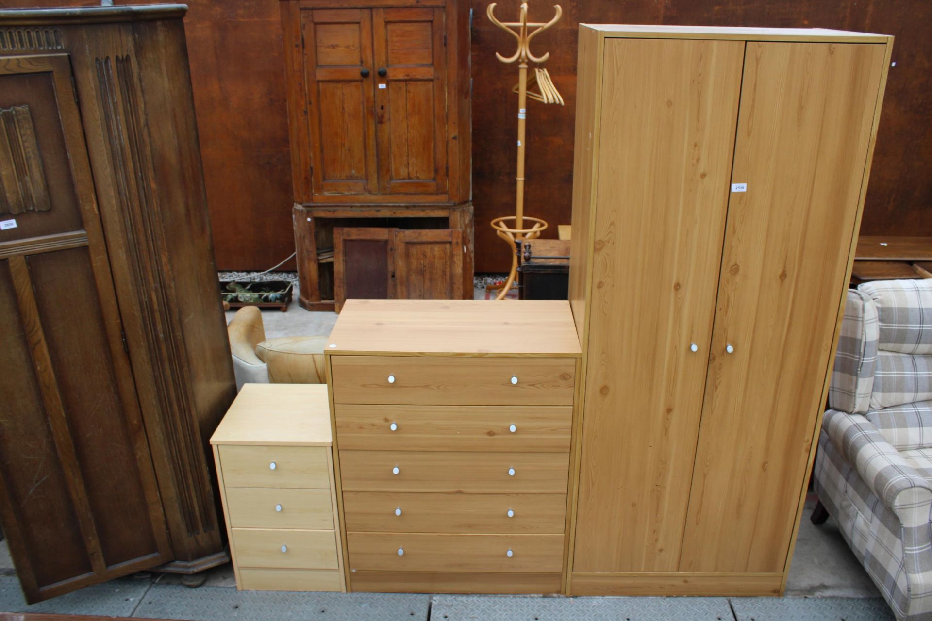 A PINE EFFECT TWO DOOR WARDROBE, CHEST OF FIVE DRAWERS AND A BEDSIDE CHEST