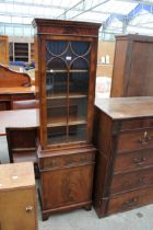A NARROW MAHOGANY CROSS BANDED AND INLAID GLAZED BOOKCASE ON BASE ENCLOSING SINGLE DRAWER AND