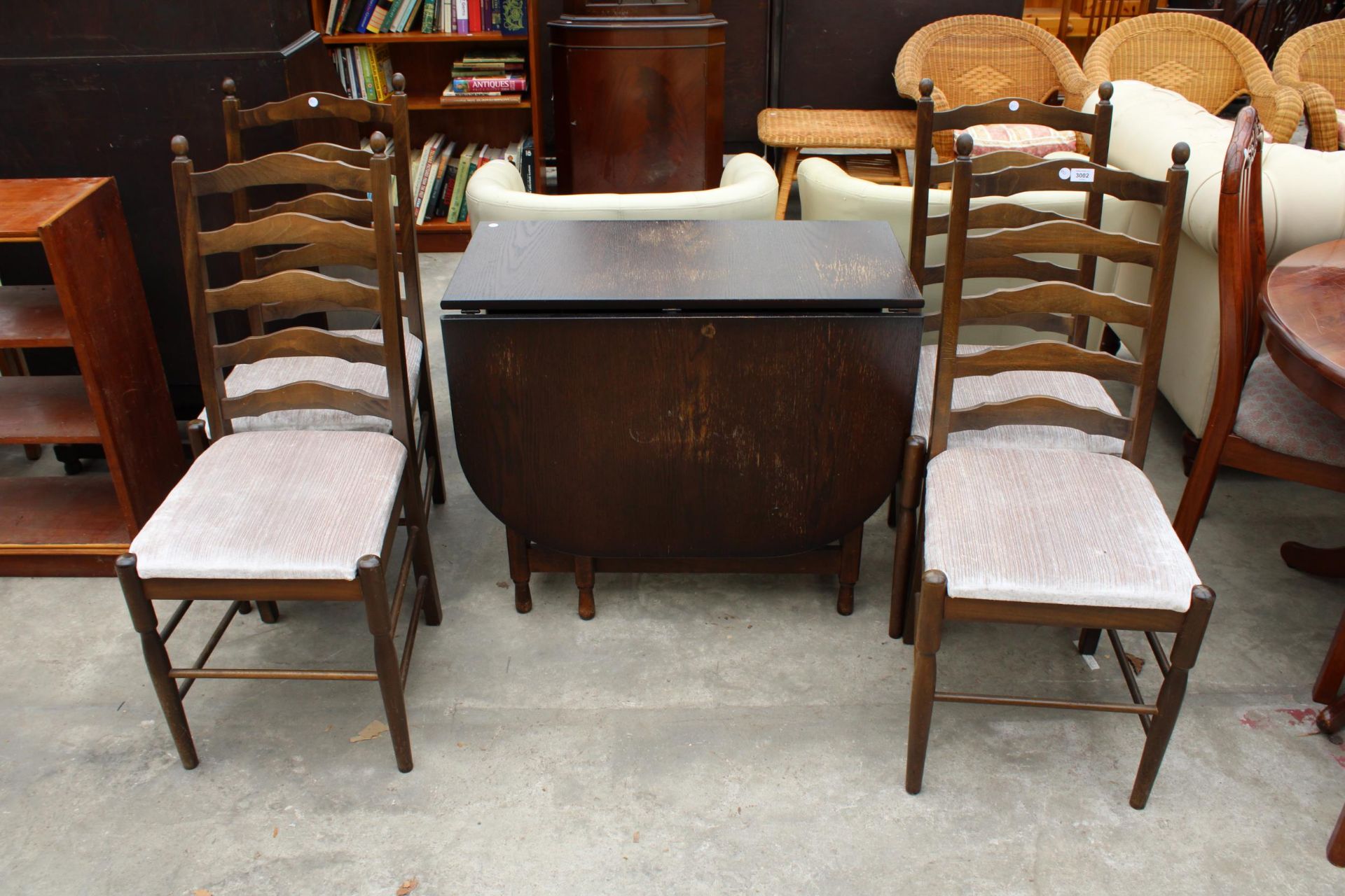 A MODERN OAK GATE-LEG DINING TABLE ON TURNED LEGS AND FOUR LADDER-BACK DINING CHAIRS