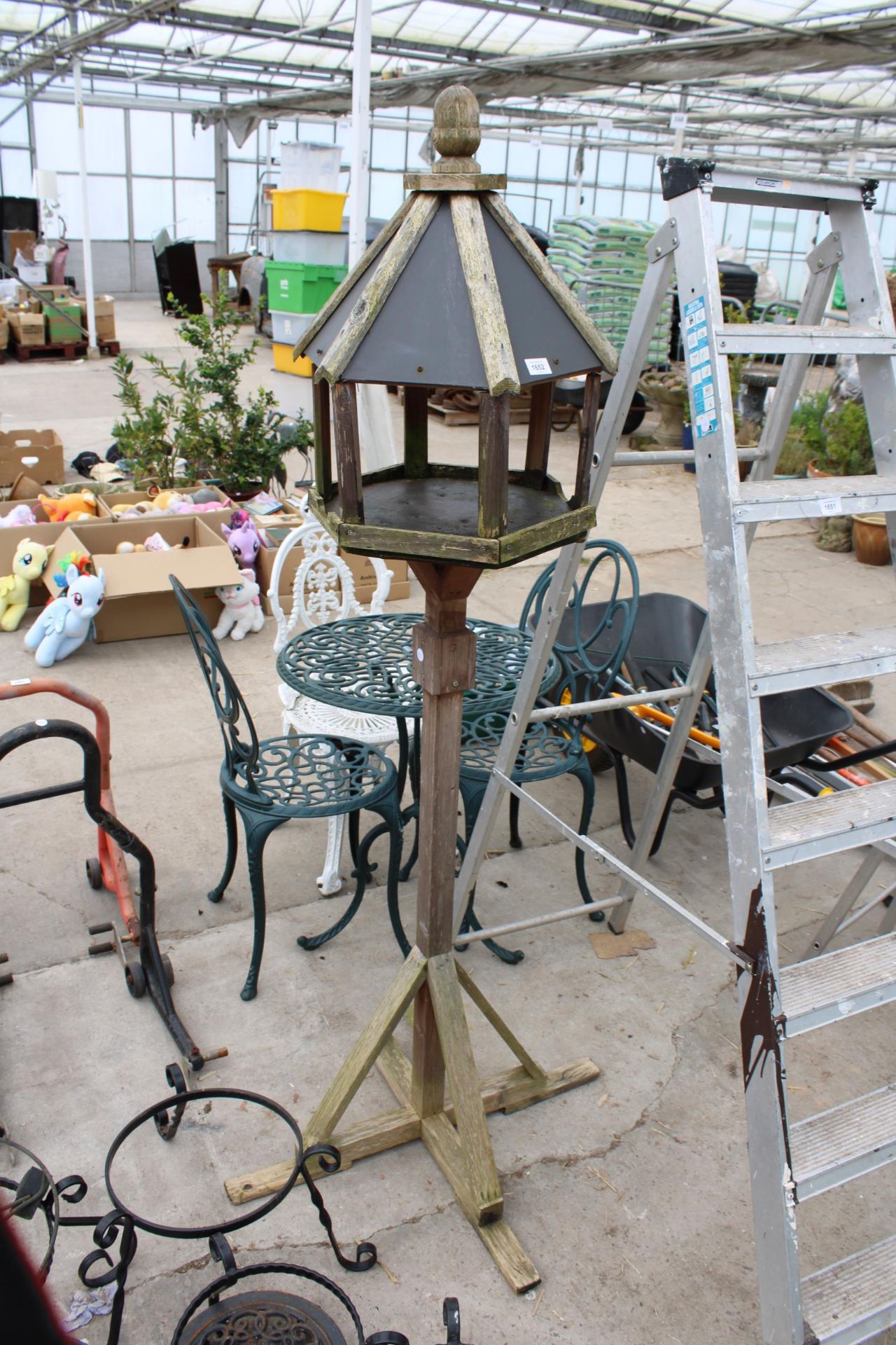 A WOODEN BIRDTABLE WITH SLATE EFFECT ROOF