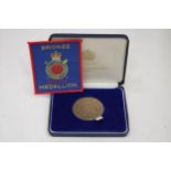A BOXED BRONZE MEDAL AND ACCOMPANYING PATCH