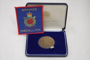 A BOXED BRONZE MEDAL AND ACCOMPANYING PATCH