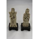 TWO ASIAN FIGURES ON BASES, WITH MARKINGS TO THE BASE, HEIGHT 22CM