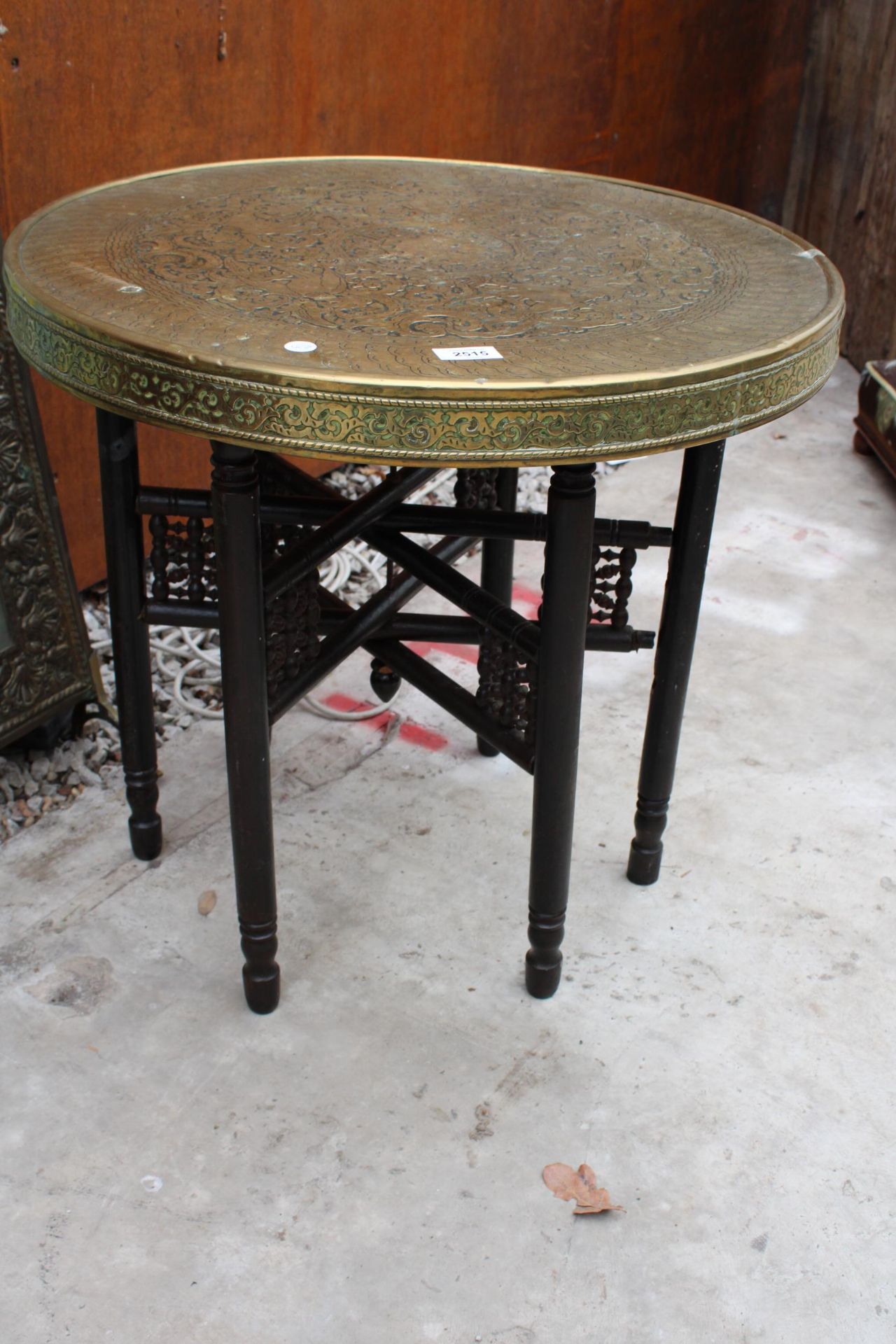 AN INDIAN STYLE BRASS TOP 23.5" SIDE TABLE ON FOLDING BASE WITH EMBOSSED BRASS FIRE GUARD - Bild 3 aus 3