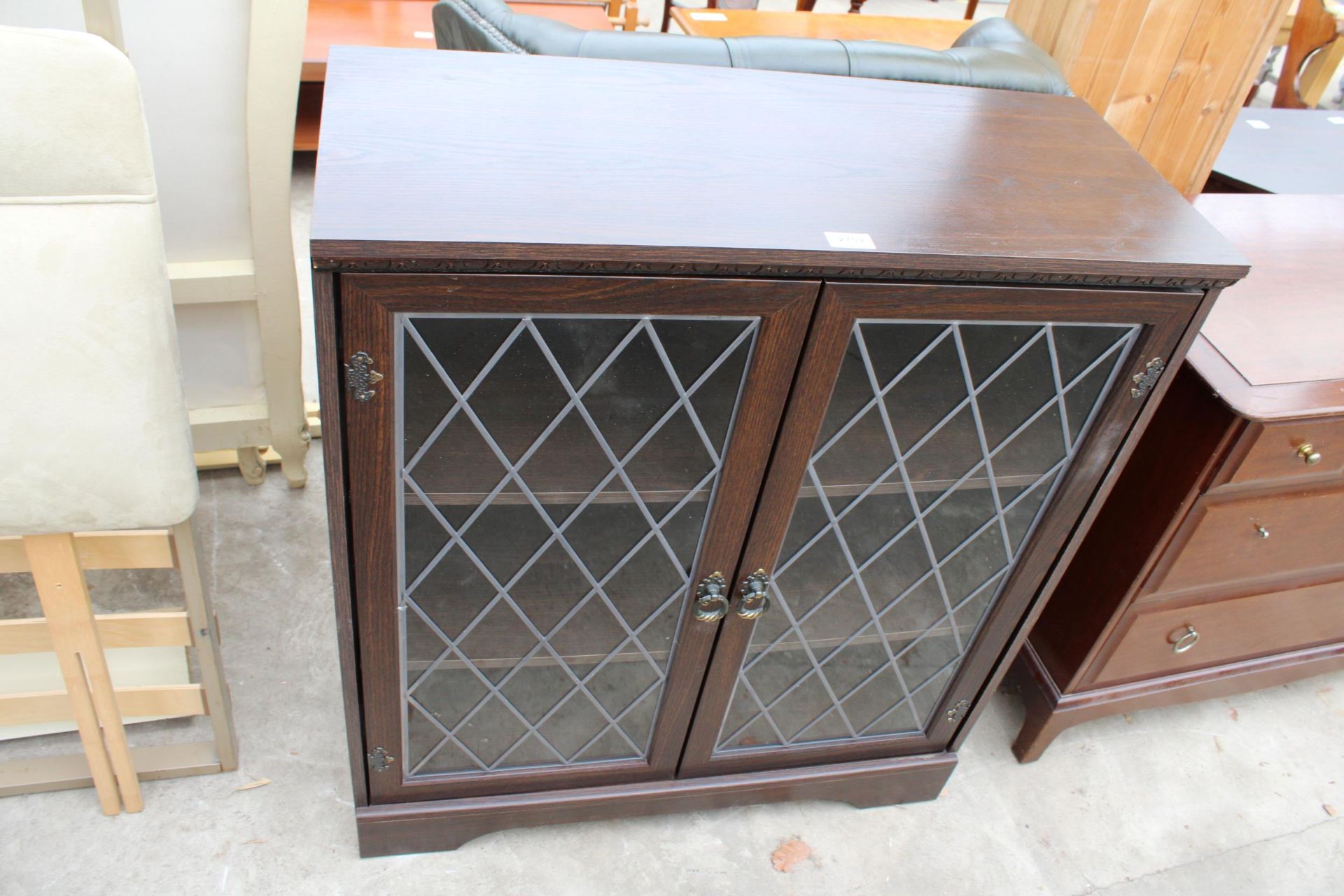 A MODERN OAK EFFECT TWO DOOR BOOKCASE WITH GLAZED AND LEADE DOORS, 32" WIDE