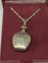 A SILVER BOTTLE NECKLACE IN A PRESENTATION BOX