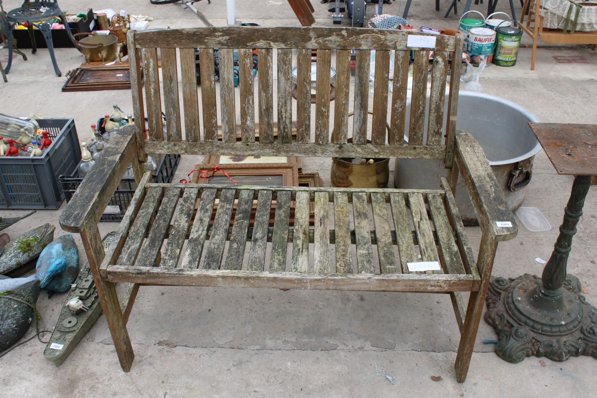 A WOODEN SLATTED GARDEN BENCH