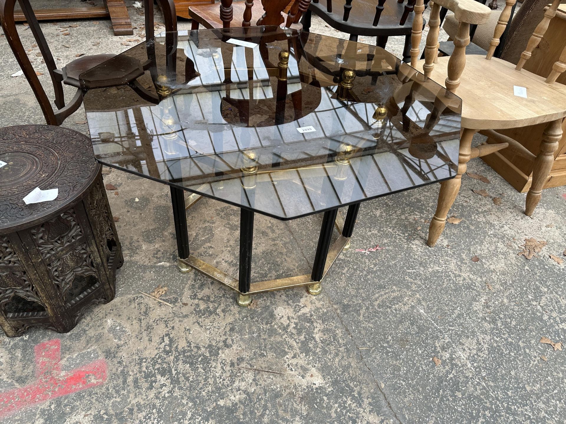 A RETRO OCTAGONAL SMOKED GLASS COFFEE TABLE ON BLACK AND BRASS EFFECT BASE