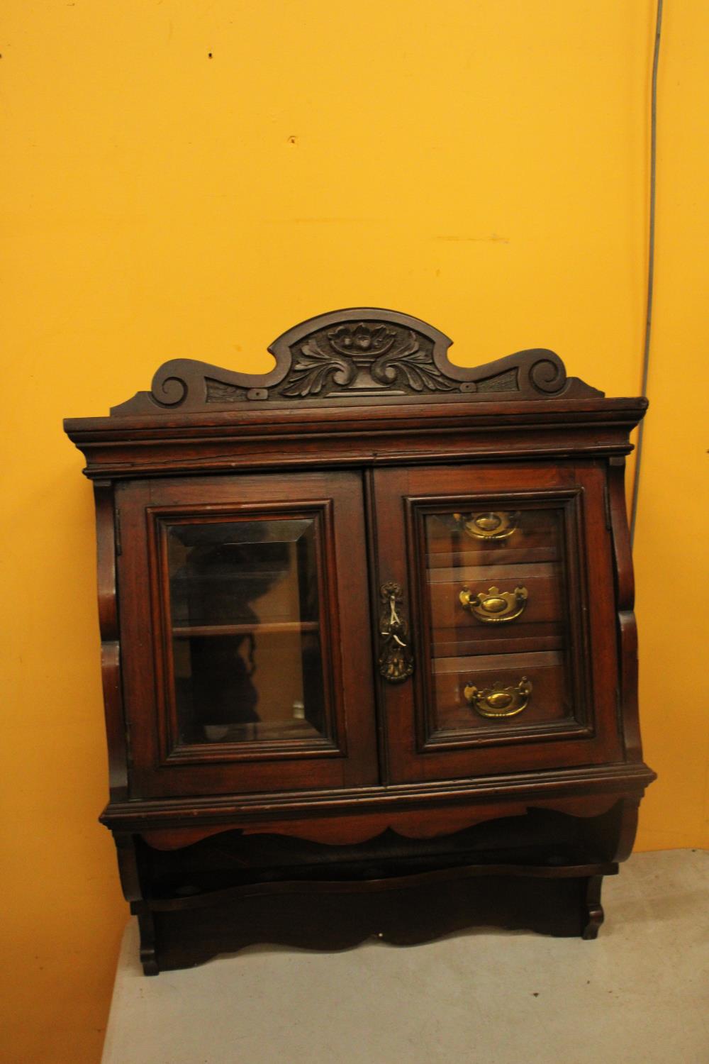 A WALLMOUNTED CABINET WITH THREE INNER DRAWERS, SHELVES AND TWO GLASS DOORS AND KEY