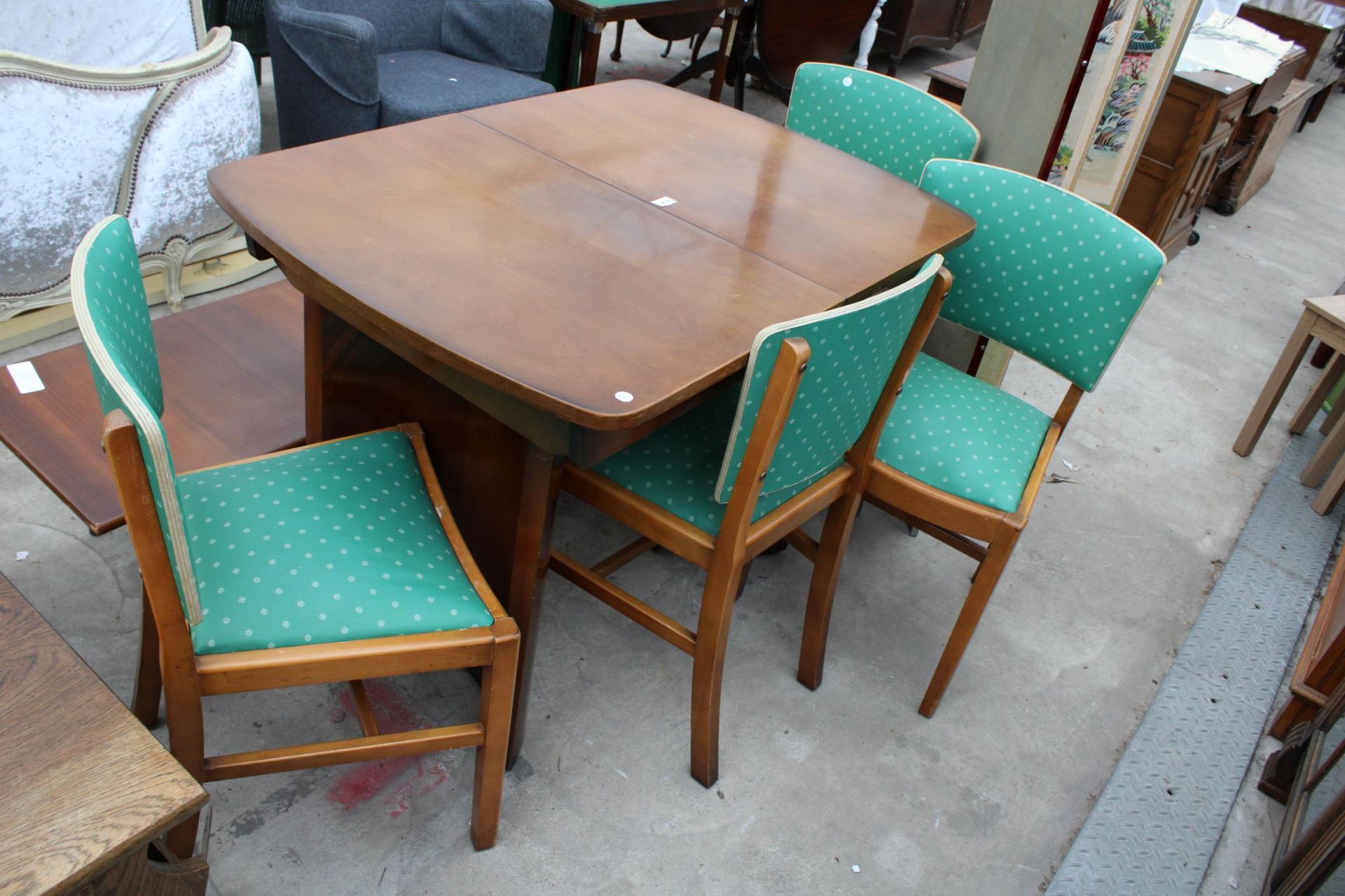 A MID 20TH CENTURY WALNUT EXTENDING DINING TABLE AND FOUR CHAIRS