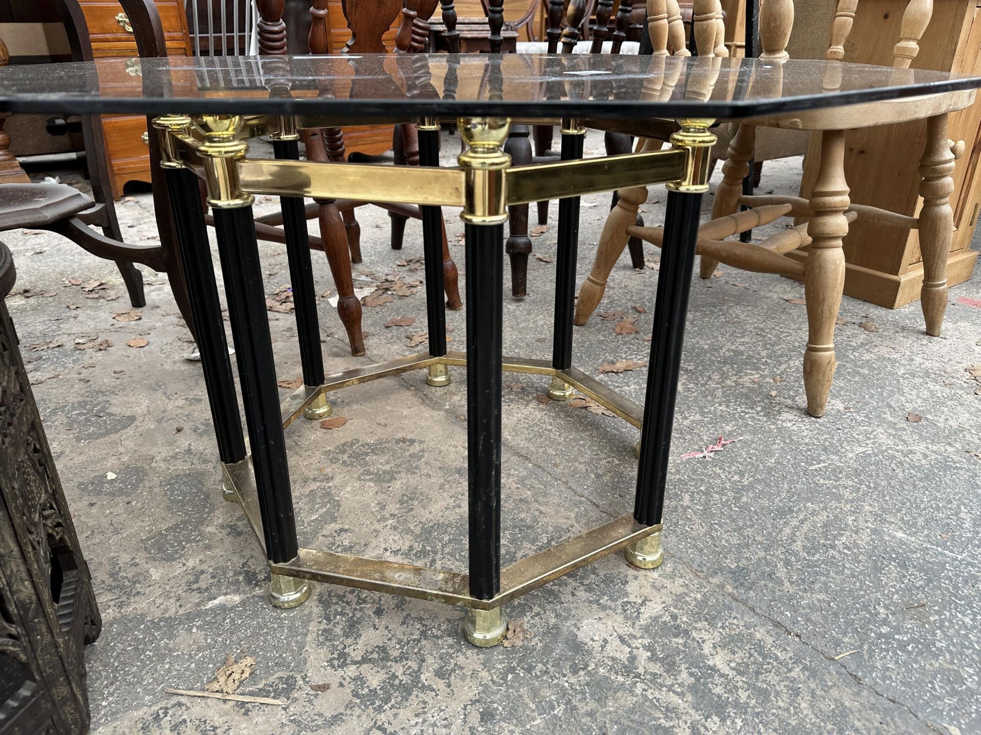 A RETRO OCTAGONAL SMOKED GLASS COFFEE TABLE ON BLACK AND BRASS EFFECT BASE - Image 3 of 3