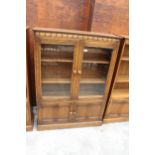 AN ERCOL BLONDE TWO DOOR BOOKCASE WITH CUPBOARD TO BASE 39.5" WIDE