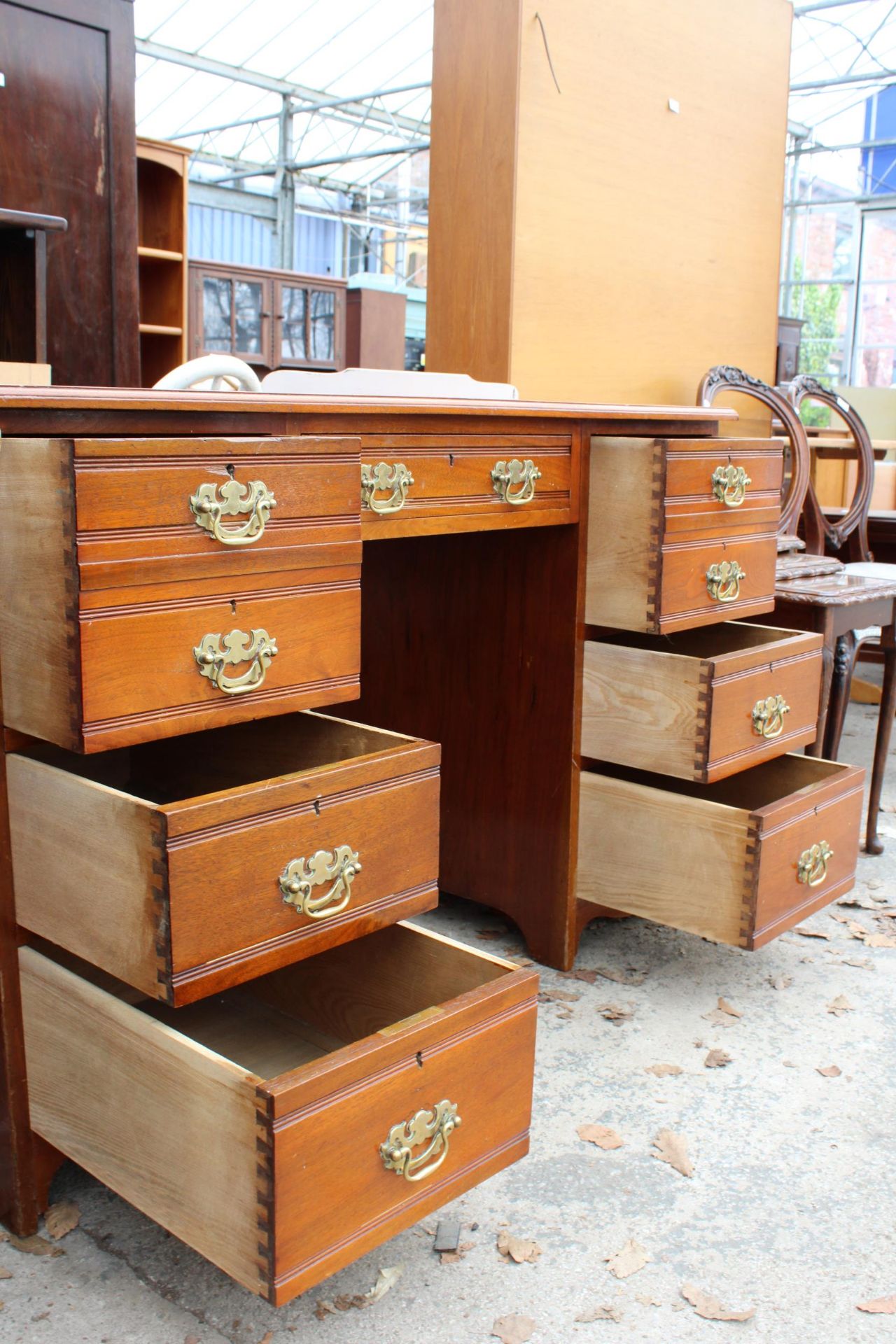 AN EDWARDIAN MAHOGANY KNEE HOLE DESK ENCLOSING SEVEN DRAWERS WITH BRASS HANDLES AND INSET LEATHER - Image 4 of 5