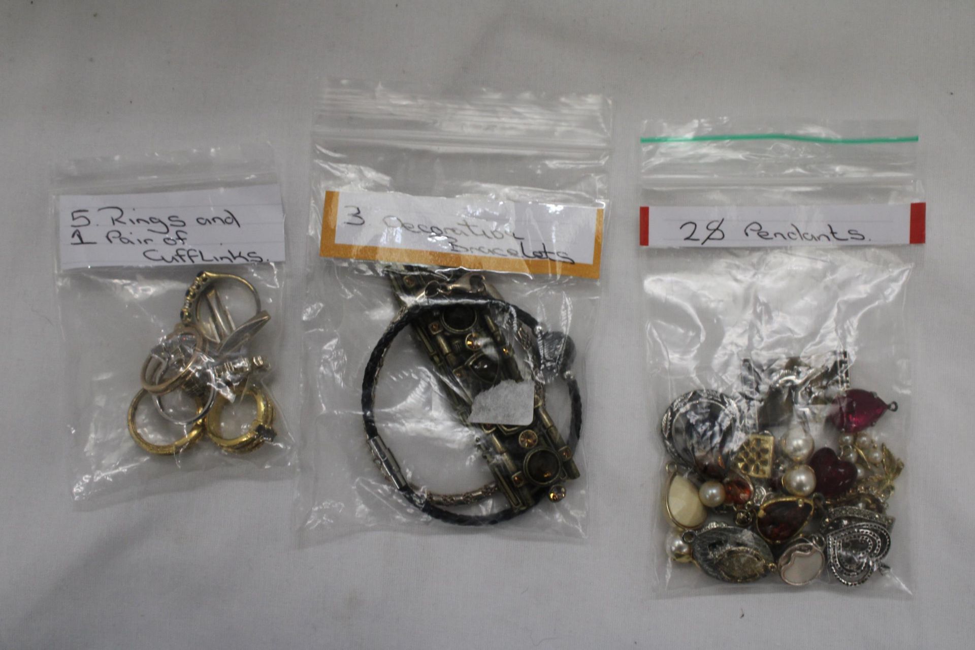 A QUANTITY OF COSTUME JEWELLERY TO INCLUDE RINGS, BRACELETS AND PENDANTS