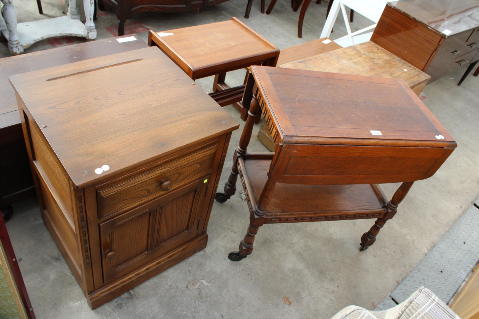 AN ERCOL BLONDE ELM BESIDE CABINET AND OAK TIER DROP-LEAF TROLLEY