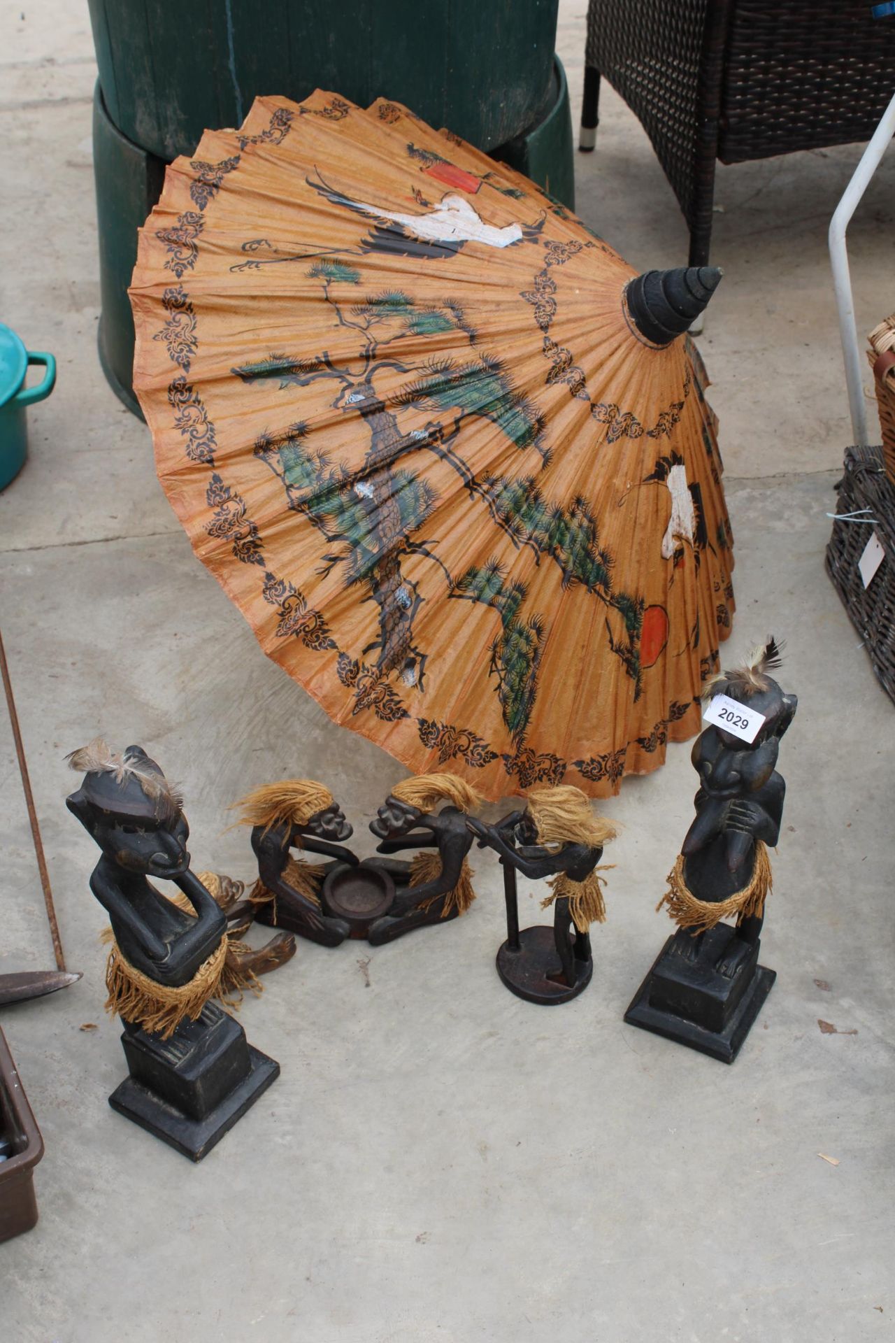 AN ORIENTAL STYLE PARASOL AND TREEN TRIBAL FIGURES