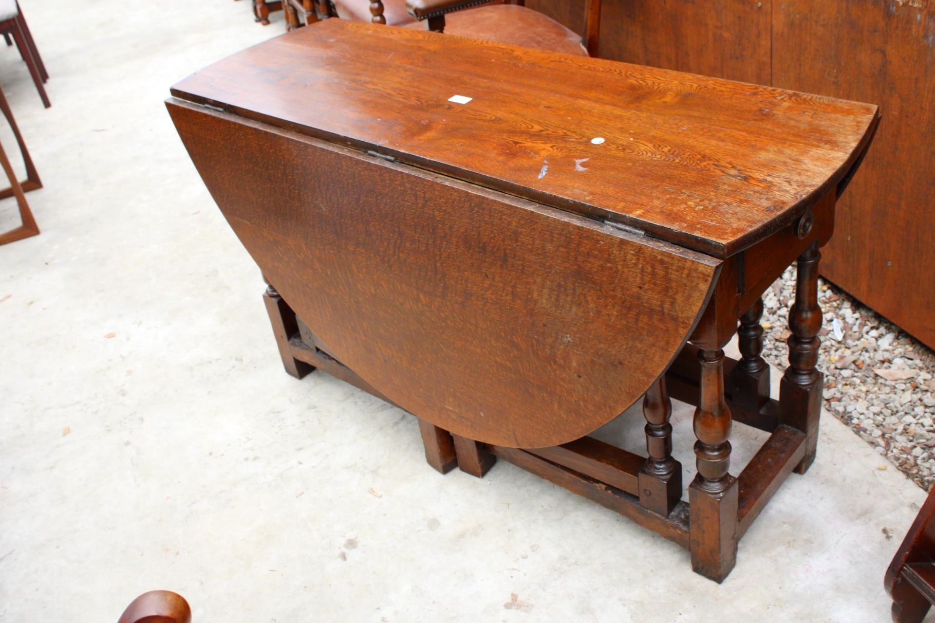 AN OAK GEORGE III OVAL GATE LEG DINING TABLE WITH TWO DRAWERS ON TURNED LEGS 59" X 53" OPENED