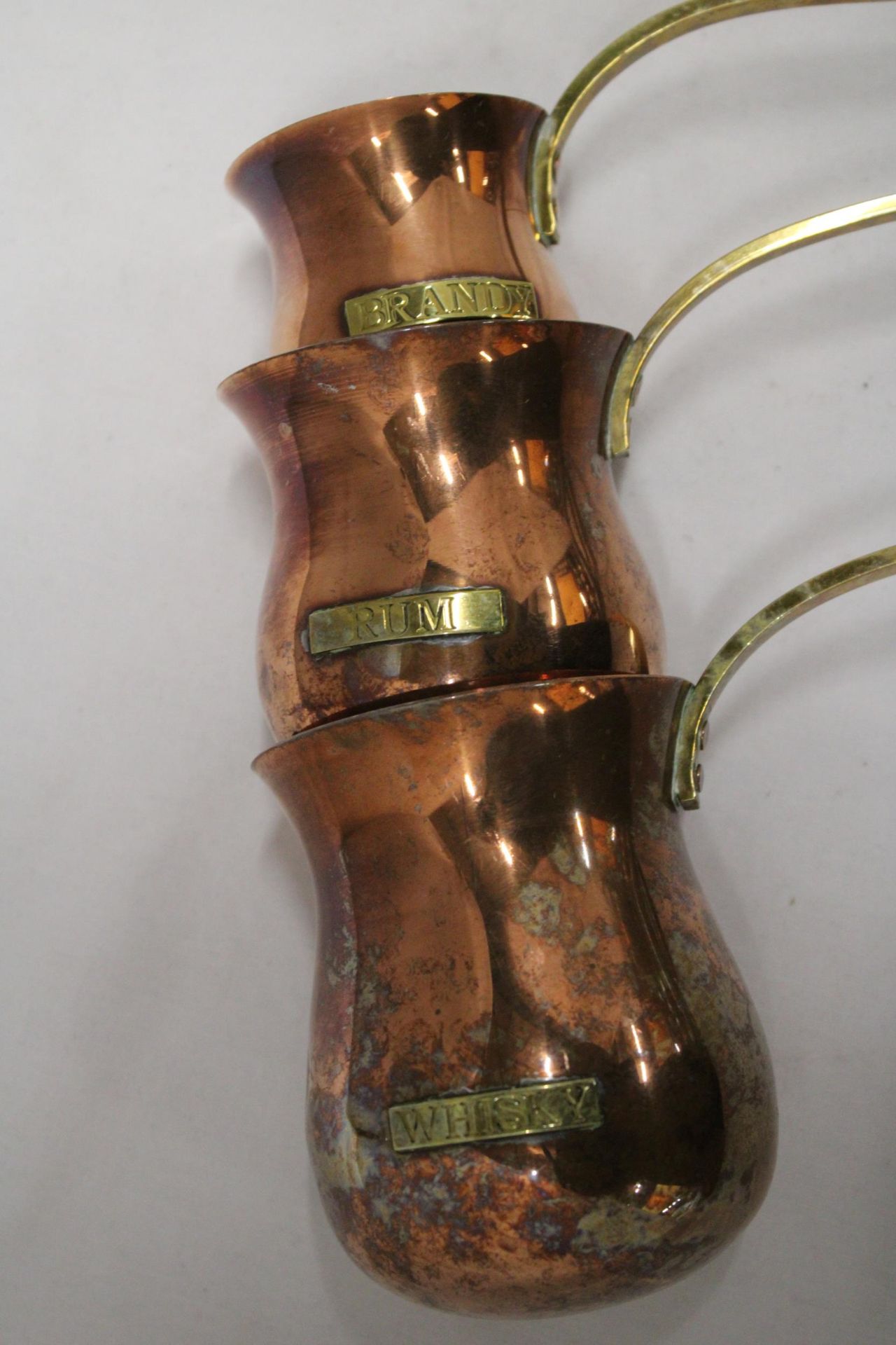 THREE VINTAGE COPPER AND BRASS MEASURING LADELS, RUM, WHISKY AND BRANDY - Image 2 of 5