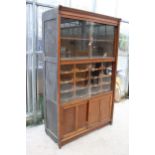 AN EARLY 20TH CENTURY OAK HABERDASHERY CABINET ENCLOSING 16 SLIDES, 4 SLIDING DOORS, 2 BEING GLASS