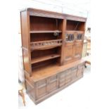 AN OAK OLD CHARM LOUNGE UNIT WITH GLAZED AND LEADED LINEN FOLD DOORS WITH CUPBOARDS AND DRAWERS TO