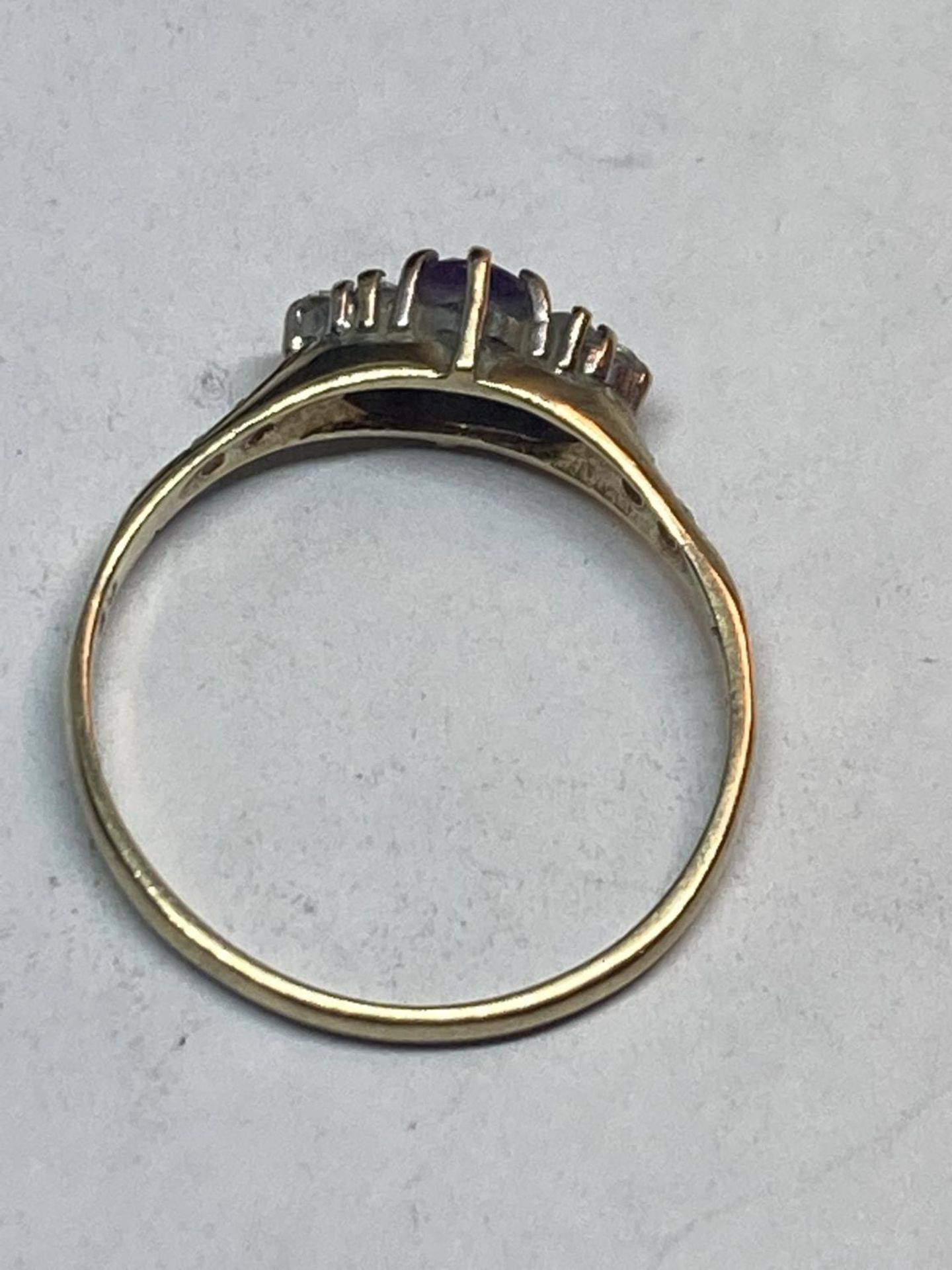 A 9 CARAT GOLD RING WITH A CENTRE AMETHYST SURROUNDED BY CUBIC ZIRCONIAS SIZE Q/R - Image 3 of 4