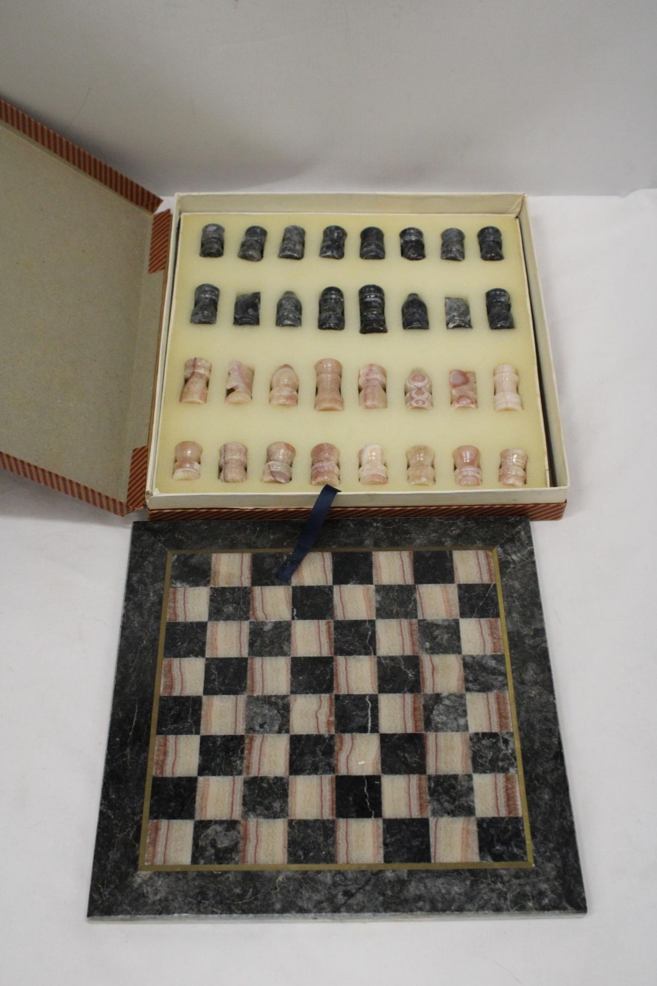 A VINTAGE MARBLE CHESS BOARD AND CHESS PIECES - COMPLETE