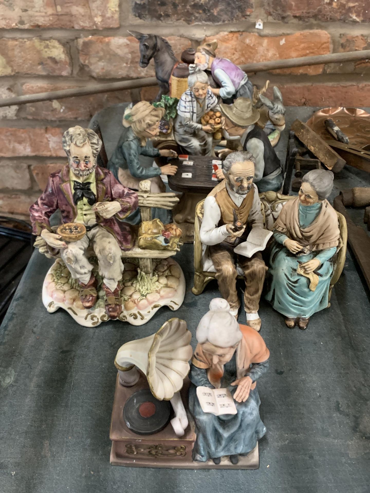 SIX CHALKWARE FIGURINES FEATURING A COUPLE PLAYING CARD GAMES, LADY WITH DONKEY AND CART ETC
