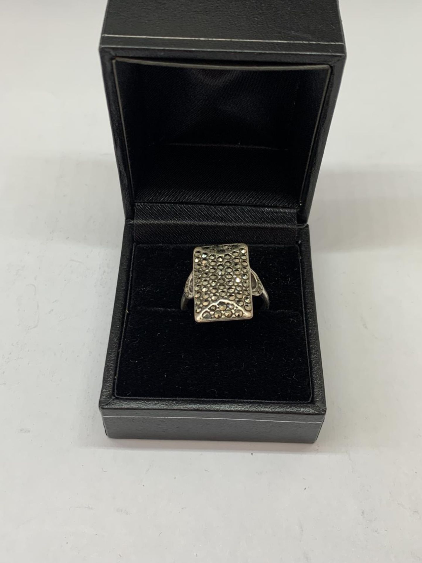 A SILVER RING IN A PRESENTATION BOX