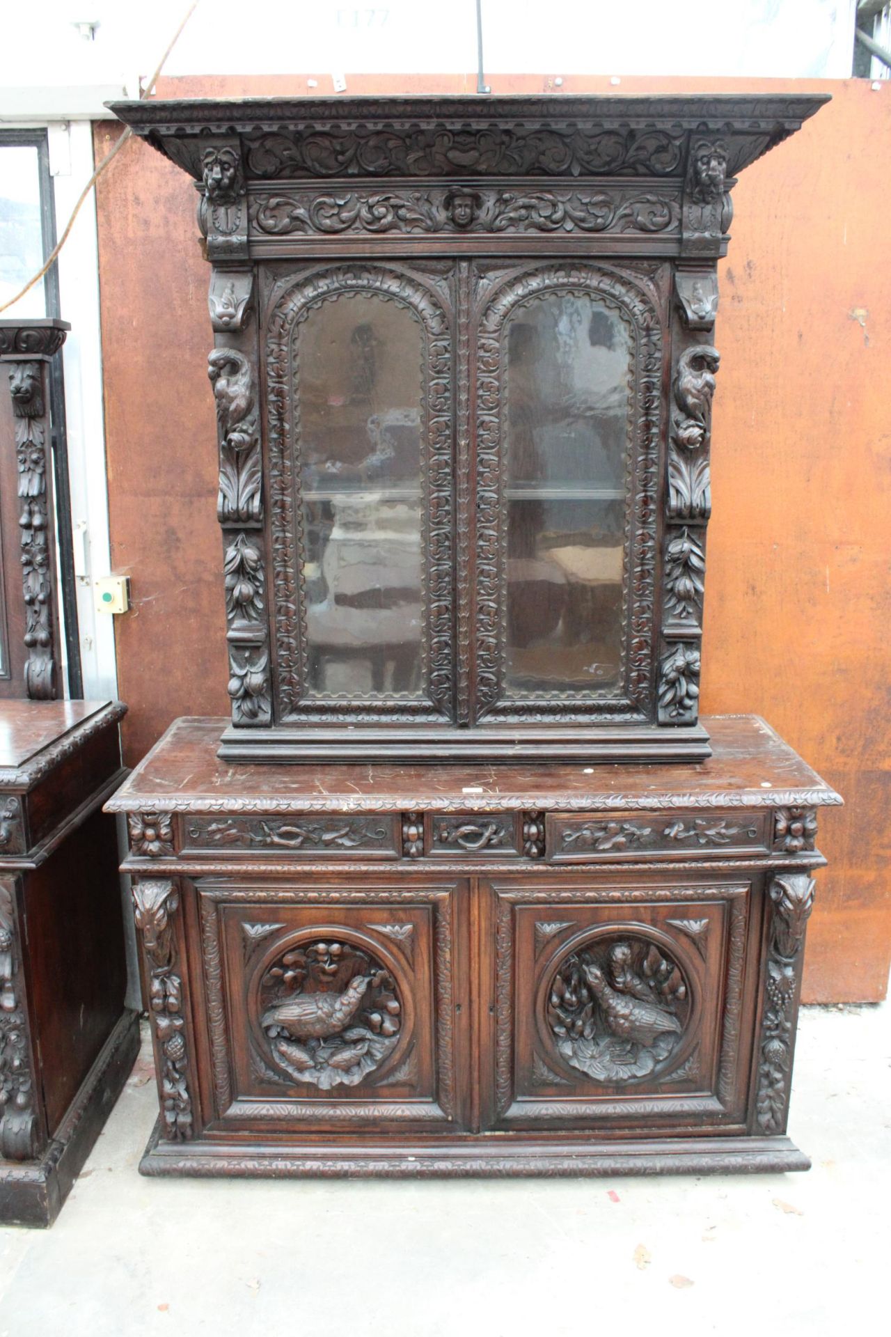 A VICTORIAN OAK BLACK FOREST STYLE SIDEBOARD WITH ASSOCIATED 2 DOOR GLAZED BOOKCASE, ALL HEAVILY