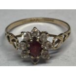 A 9 CARAT GOLD RING WITH A CENTRE RUBY SURROUNDED BY CUBIC ZIRCONIAS WITH HEART DESIGN SHOULDERS R