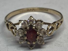 A 9 CARAT GOLD RING WITH A CENTRE RUBY SURROUNDED BY CUBIC ZIRCONIAS WITH HEART DESIGN SHOULDERS R