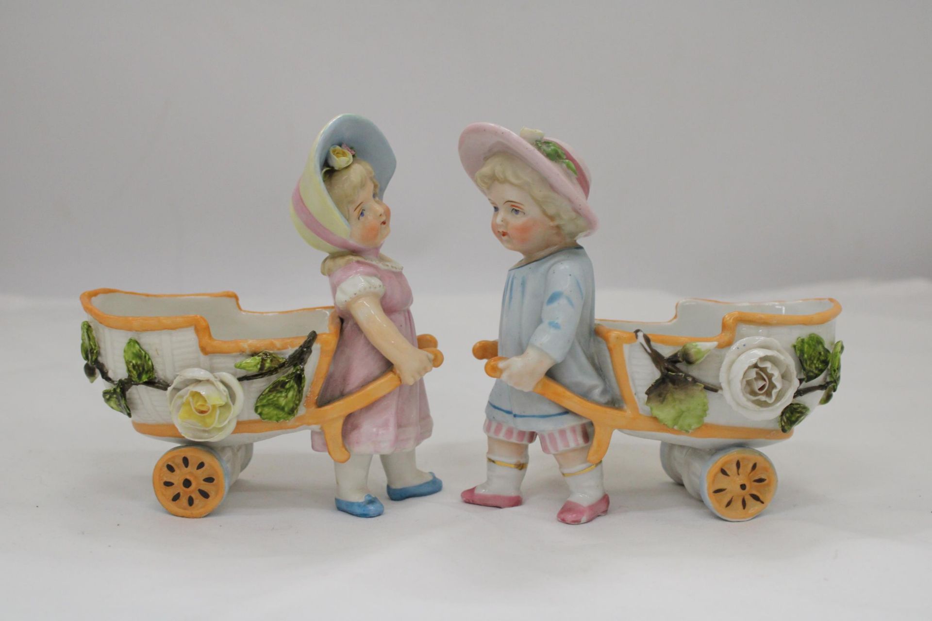 TWO VINTAGE CONTA AND BOHME GERMAN FAIRINGS TO INCLUDE TWO GIRLS PULLING FLOWER CARTS, ONE WITH A - Image 3 of 5