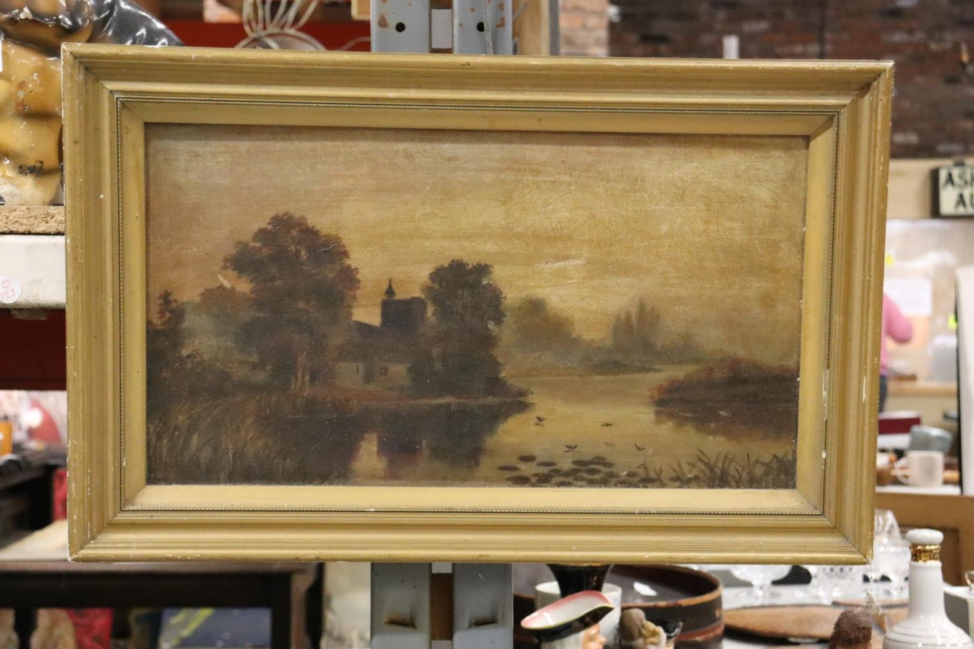 AN OIL ON CANVAS OF A COUNTRY SCENE WITH BIRDS ON A LAKE