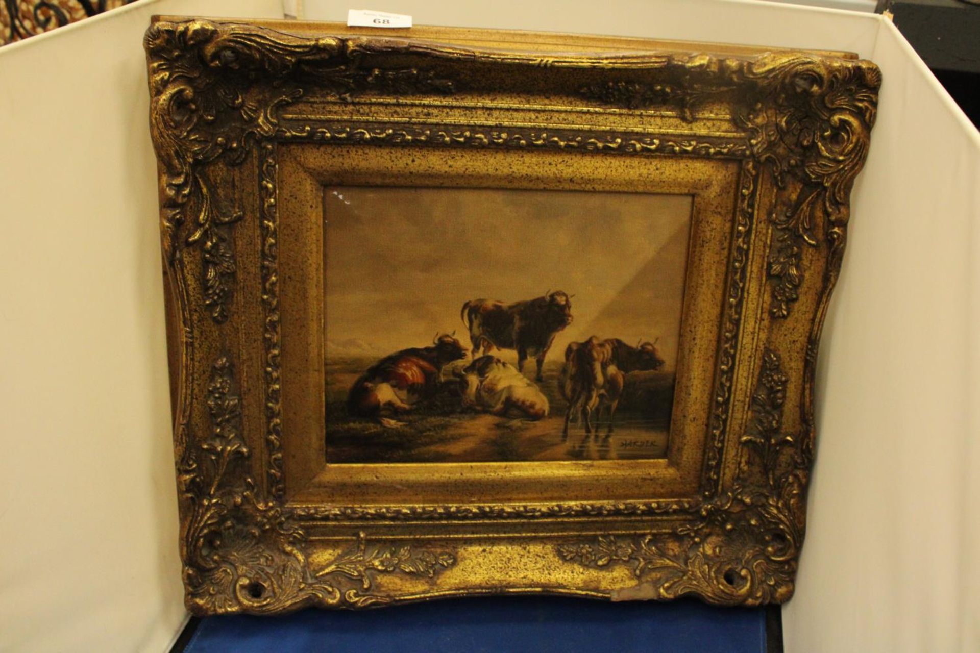 A GILT FRAMED OIL ON CANVAS SIGNED HARDER OF THREE COWS AND A BULL RESTING 19" X 25"