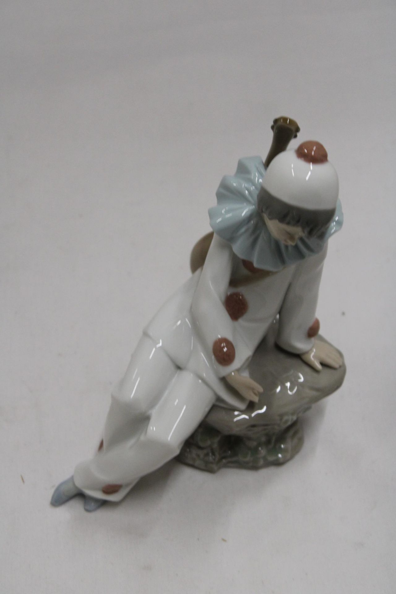 A NAO FIGURINE OF A CLOWN ON A ROCK