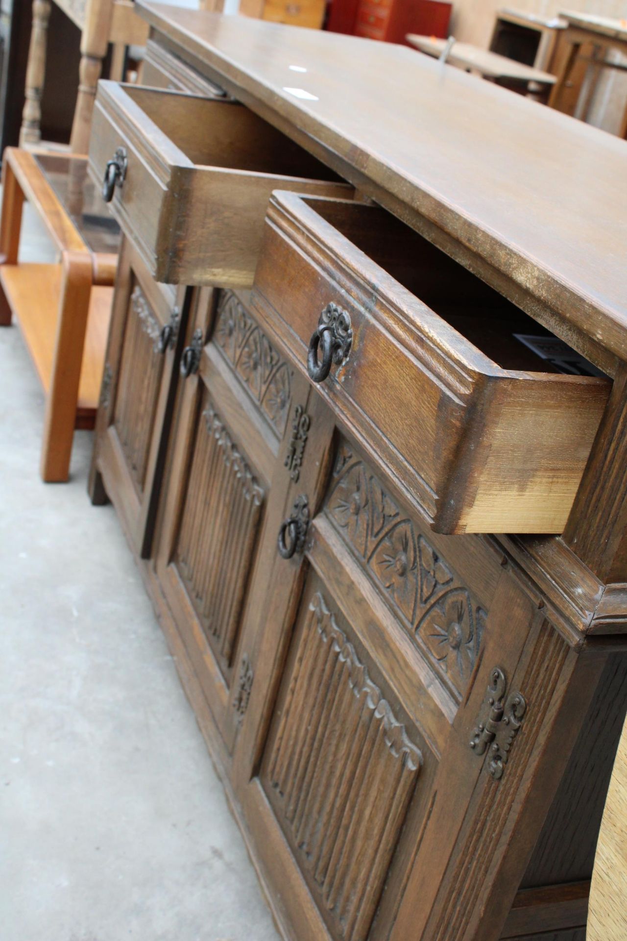 A REPRODUCTION OAK DRESSER WITH THREE LINENFOLD DOORS AND THREE DRAWERS, 54" WIDE - Image 2 of 2