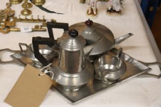 A VINTAGE HAMMERED PEWTER TEASET TO INCLUDE A TRAY, TEAPOT, HOT WATER JUG, CREAM JUG AND SUGAR BOWL
