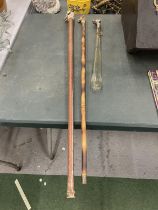 TWO CARVED DOG HEAD WALKING STICKS AND A WHITE METAL DOG HEAD SHOE HORN