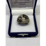 A SILVER AND BLACK RING IN A PRESENTATION BOX