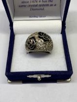 A SILVER AND BLACK RING IN A PRESENTATION BOX