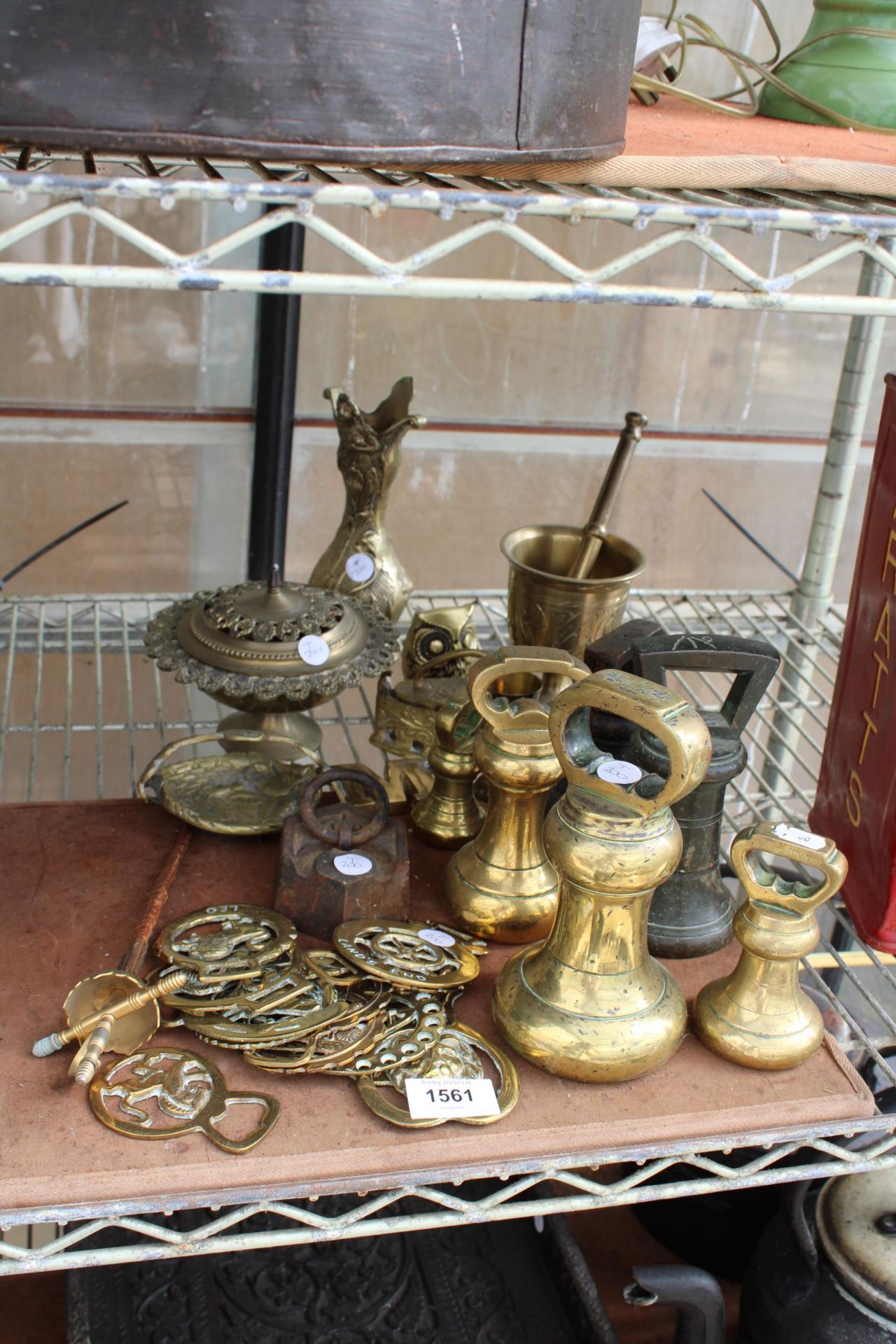 AN ASSORTMENT OF BRASS ITEMS TO INCLUDE BELL WEIGHTS, A PESTAL AND MORTAR AND HORSE BRASSES ETC