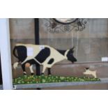 A METAL WALL PLAQUE OF A DOG AND A COW