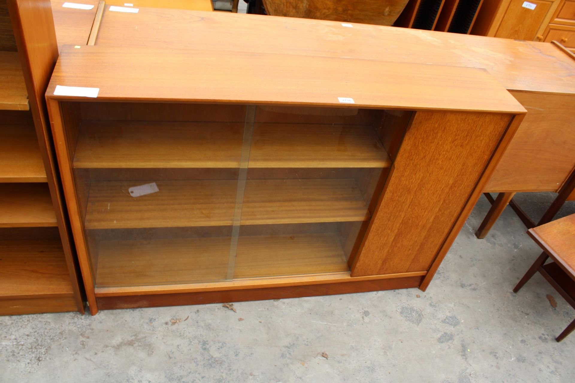 A RETRO TEAK GIBBS FURNITURE BOOKCASE ENCLOSING CUPBOARDS AND TWO GLASS SLIDING DOORS, 48" WIDE