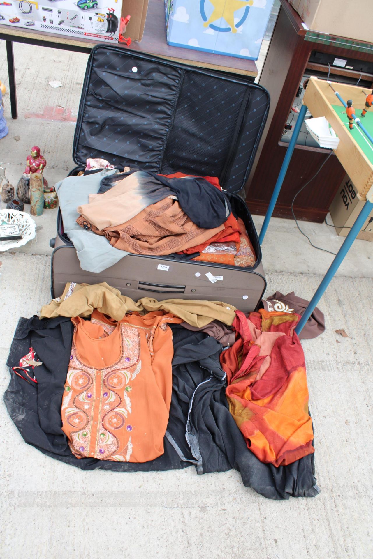 A SUITCASE CONTAINING A LARGE ASSORTMENT OF CLOTHES